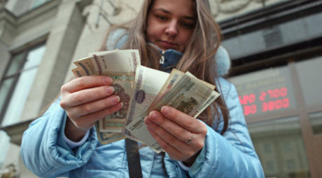Девушка у обмена валюты в Минске. Фото: PhotoXPress