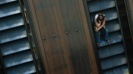 Девушка сидит на эскалаторе, едущем вниз. Фото: Brian Jeffery Beggerly/flickr.com