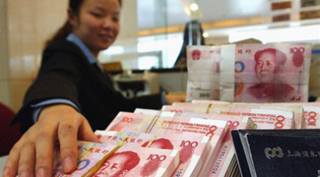 Работник банка с юанями. Фото: AFP
