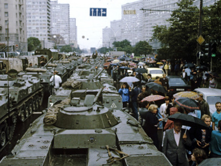 Негероический, но оттого еще более поразительный эпизод августа 1991 года: москвичи под зонтиками проталкиваются между БТР на Калининском проспекте (ныне Новый Арбат). Фото: РИА Новости