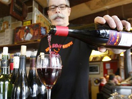 Жак, владелец ресторана Bistrot Mélac, наливает Beaujolais nouveau своим клиентам, Париж, Франция. Фото: АР