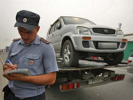 Сотрудник ГИБДД заполняет протокол задержания транспортного средства. Фото: РИА Новости