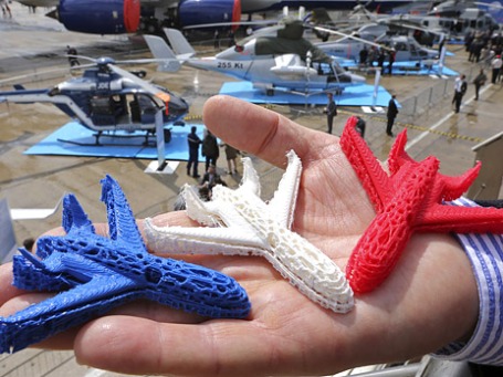 Сотрудник компании Airbus держит на ладони модели самолетов, напечатанные на 3D-принтере, на международном авиасалоне Ле Бурже во Франции. Фото: Reuters