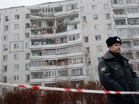 Сотрудник правоохранительных органов перед девятиэтажным домом в поселке Загорские Дали на севере Московской области, в котором произошел взрыв бытового газа. Фото: РИА Новости