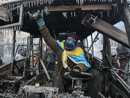 Сторонник евроинтеграции позирует в сожженом милицейском автобусе. Фото: Reuters