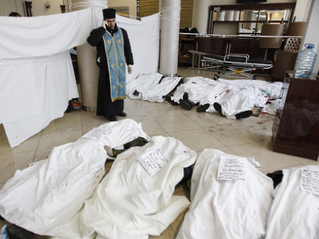 Священник в холле гостиницы Украина возле тел погибших участников антиправительственных демонстраций в Киеве. Фото: Reuters