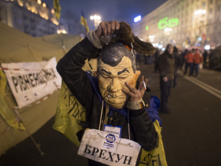 Фото: РИА Новости. Сторонник евроинтеграции Украины в маске, изображающей президента страны Виктора Януковича, в палаточном лагере на площади Независимости в Киеве