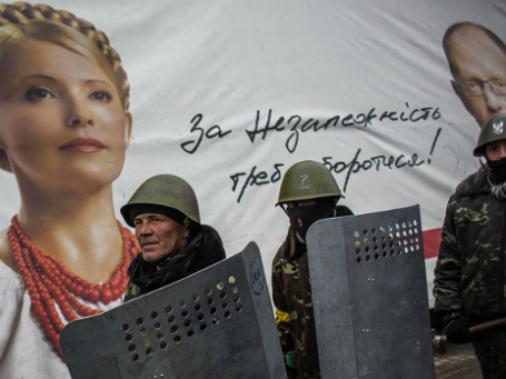 Бойцы из отряда «Самообороны Майдана» на улице Крещатик возле плаката с изображением Юлии Тимошенко. Фото: РИА Новости.