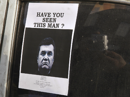 Фотография разыскиваемого Виктора Януковича на стекле одной из машин рядом с Майданом. Фото: Reuters