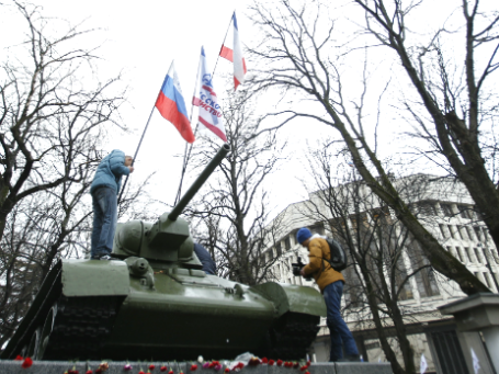 Участники митинга устанавливают российский флаг недалеко от здания Верховного совета Крыма в Симферополе. Фото: Reuters