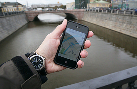 Житель города смотрит карты на Iphone.