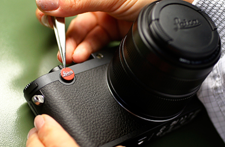 Сотрудник немецкого производителя камер Leica Camera AG помещает культовую эмблему на Leica X Vario.