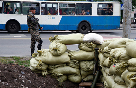 Проросийсский боец ​​из батальона «Восток»стоит на страже на КПП в Донецке.