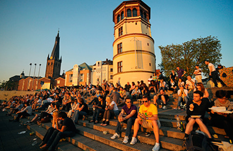 Горожане во время отдыха на набережной реки Рейн в Дюссельдорфе, Германия.