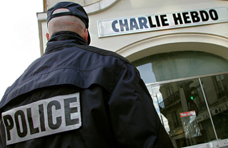 Полицейский около входа в редакцию французского сатирического еженедельника Charlie Hebdo в Париже.