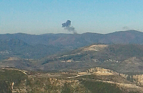 Дым поднимается на месте сбитого бомбардировщика Су-24.