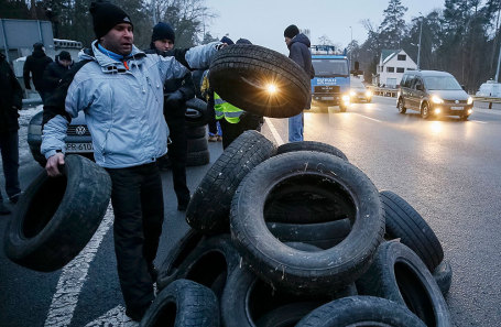 Протестующие активисты на окраине Киева собирают покрышки, чтобы их поджечь.