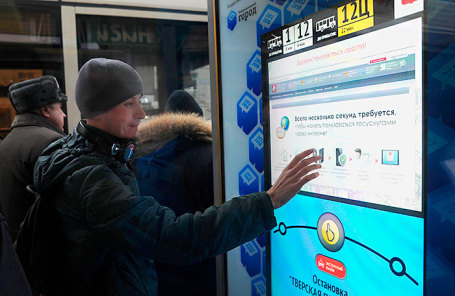 Пассажир во время использования сервиса на интерактивной остановке на улице Тверская.
