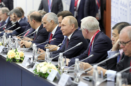 Президент России Владимир Путин (в центре) во время встречи с руководителями иностранных компаний.