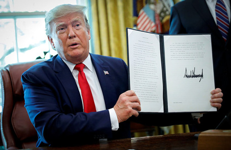 Дональд Трамп демонстрирует распоряжение о введении санкций в отношении Ирана.
