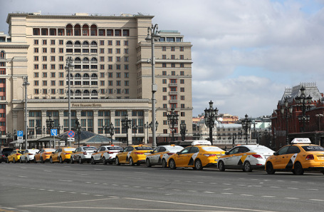 Автомобили такси на Моховой улице в Москве.