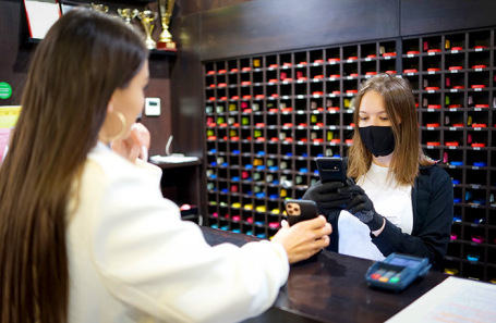 Сотрудница фитнесс-клуба во время проверки QR-кода.