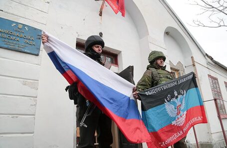 Военнослужащие ДНР с флагами России и ДНР возле здания сельсовета в Николаевке, села, перешедшего под контроль войск Донецкой Народной Республики. 