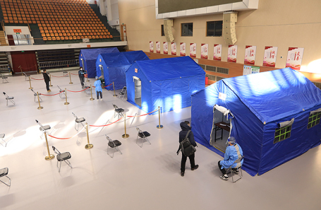 Люди обращаются за помощью в импровизированную клинику, развернутую внутри стадиона, на фоне вспышки коронавируса.