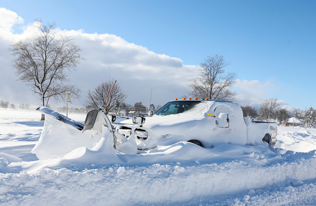 Снегоочиститель застрял на дороге после зимнего шторма, обрушившегося на район Баффало на Мейн-стрит в Амхерсте, штат Нью-Йорк, США.