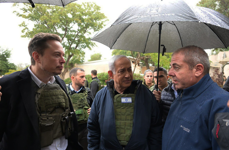 Премьер-министр Израиля Биньямин Нетаньяху (в центре) и глава SpaceX и Tesla Илон Маск (слева) во время встречи с жителями кибуца на границе с сектором Газа, пострадавшего от нападения террористов ХАМАС.