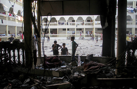 Палестинцы осматривают разрушения на месте израильского удара по школе в городе Газа.