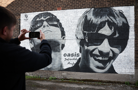 Мурал с портретами участников британской группы Oasis Лиама и Ноэля Галлахеров на одной из улиц Манчестера. Группа воссоединилась спустя 15 лет после распада и объявила даты новых концертов в 2025 году.
