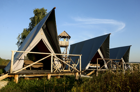 Палатки в глэмпинг-парке на берегу озера Большой Барчикуль в Кемеровской области.