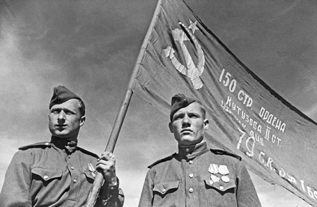 Разведчики младший сержант Мелитон Кантария и сержант Михаил Егоров (слева направо) со штурмовым флагом 150-й Идрицкой ордена Кутузова II степени стрелковой дивизии (знамя Победы), который был водружен ими на крыше Рейхстага. Берлин, май 1945 года.