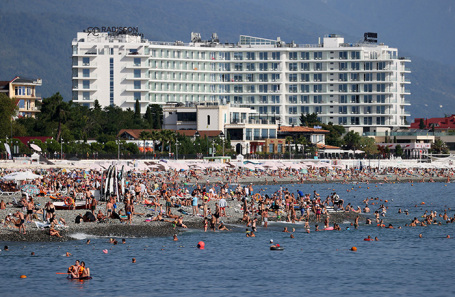Tourists relaxing on a beach, representing velvet season travel and domestic tourism trends.