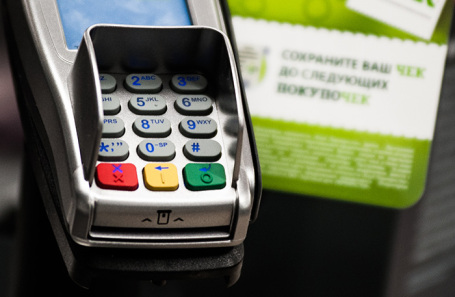 A person making a contactless payment with a bank card.