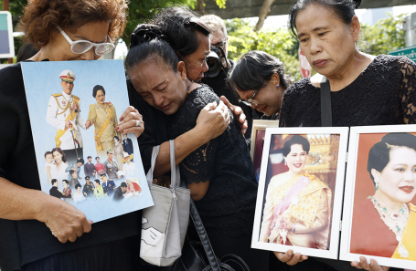 Люди с портретами королевы Сирикит на акции памяти. 