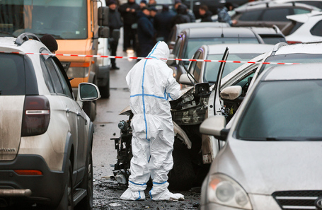 Сотрудник спецслужб на месте взрыва автомобиля Kia Sorento на парковке во дворе дома 12 по Ясеневой улице. 