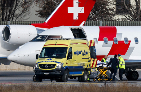 Погрузка пострадавших при пожаре в баре Le Constellation на борт самолета скорой помощи.