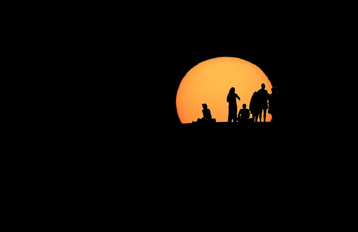 Туристы наблюдают закат на острове Гран-Канария (один из Канарских островов недалеко от северо-западного побережья Африки). Испания.