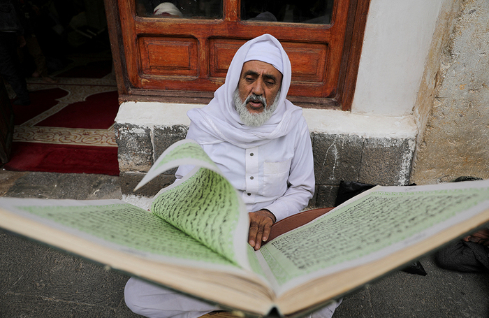 Мужчина читает Коран в Большой мечети во время священного месяца Рамадан в Сане, Йемен.