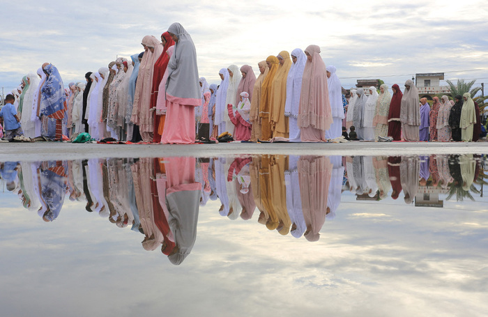 Индонезийские мусульмане совершают массовые молитвы в мечете Байтул Макмур Меулабох во время празднования Курбан-байрама в Меулабохе. Провинция Ачех, Индонезия.