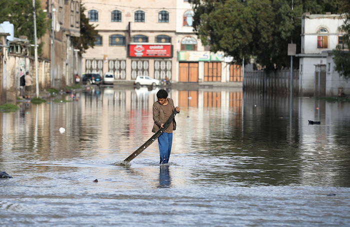 Мальчик играет на затопленной после проливных дождей улице в Сане, Йемен.