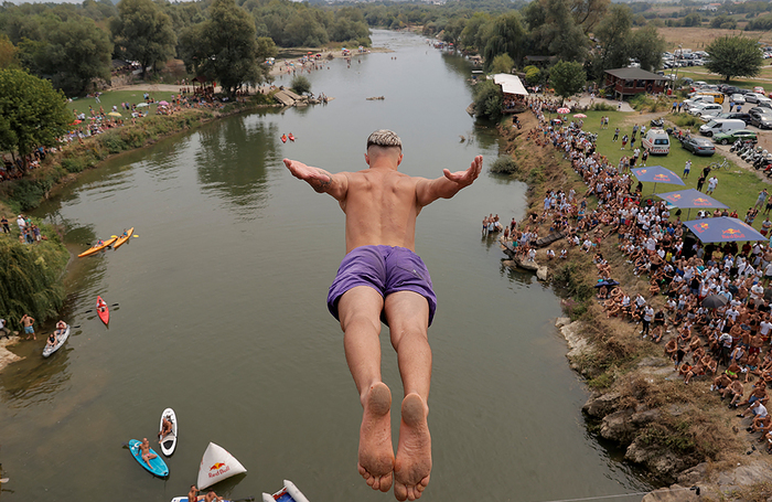 Спортсмен прыгает с 22-метрового моста в реку Белый Дрин во время традиционного соревнования по прыжкам в воду недалеко от города Джакова, Косово.