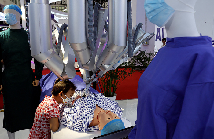 Хирургический робот Shurui, управляемый с пульта, проводит «операцию» на манекене на Всемирной конференции робототехники в Пекине, Китай.