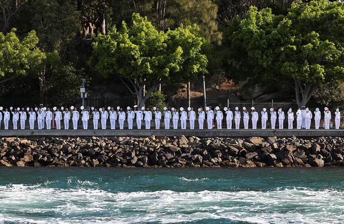 Матросы отдают честь королю Великобритании Чарльзу и королеве Камилле во время их визита в Сиднейскую гавань.