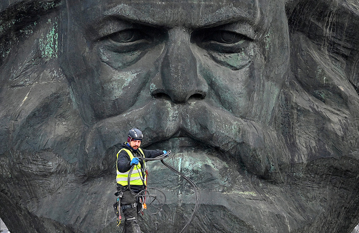 Рабочий напротив памятника Карлу Марксу в немецком Хемнице, город в 2025 году объявлен культурной столицей Европы.