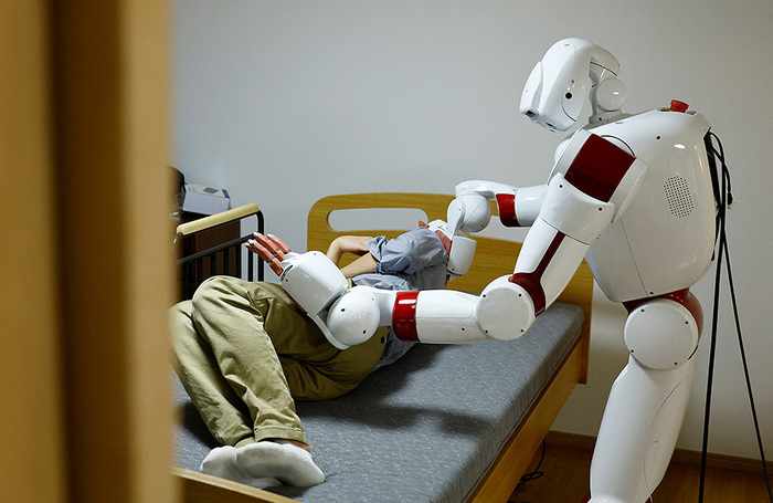 Человекоподобный робот AIREC, под управлением искусственного интеллекта, демонстрирует способности по уходу за лежачими больными. Лаборатория университета Васэда в Токио, Япония.