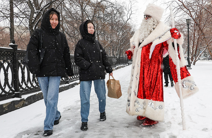 Мужчина в костюме Деда Мороза во время снегопада в Центральном районе Новосибирска. 