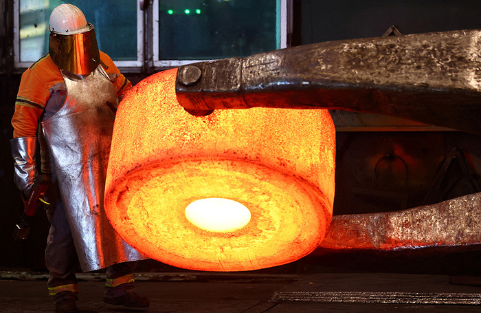 Кузнец немецкой компании Dirostahl, производящей крупногабаритные кованые изделия, работает над раскаленной стальной деталью, нагретой в классической газовой печи до температуры 1200 градусов Цельсия. Ремшайд, Германия. Компания планировала отказаться от газа в пользу водорода, но не смогла из-за высоких затрат и логистических сложностей.